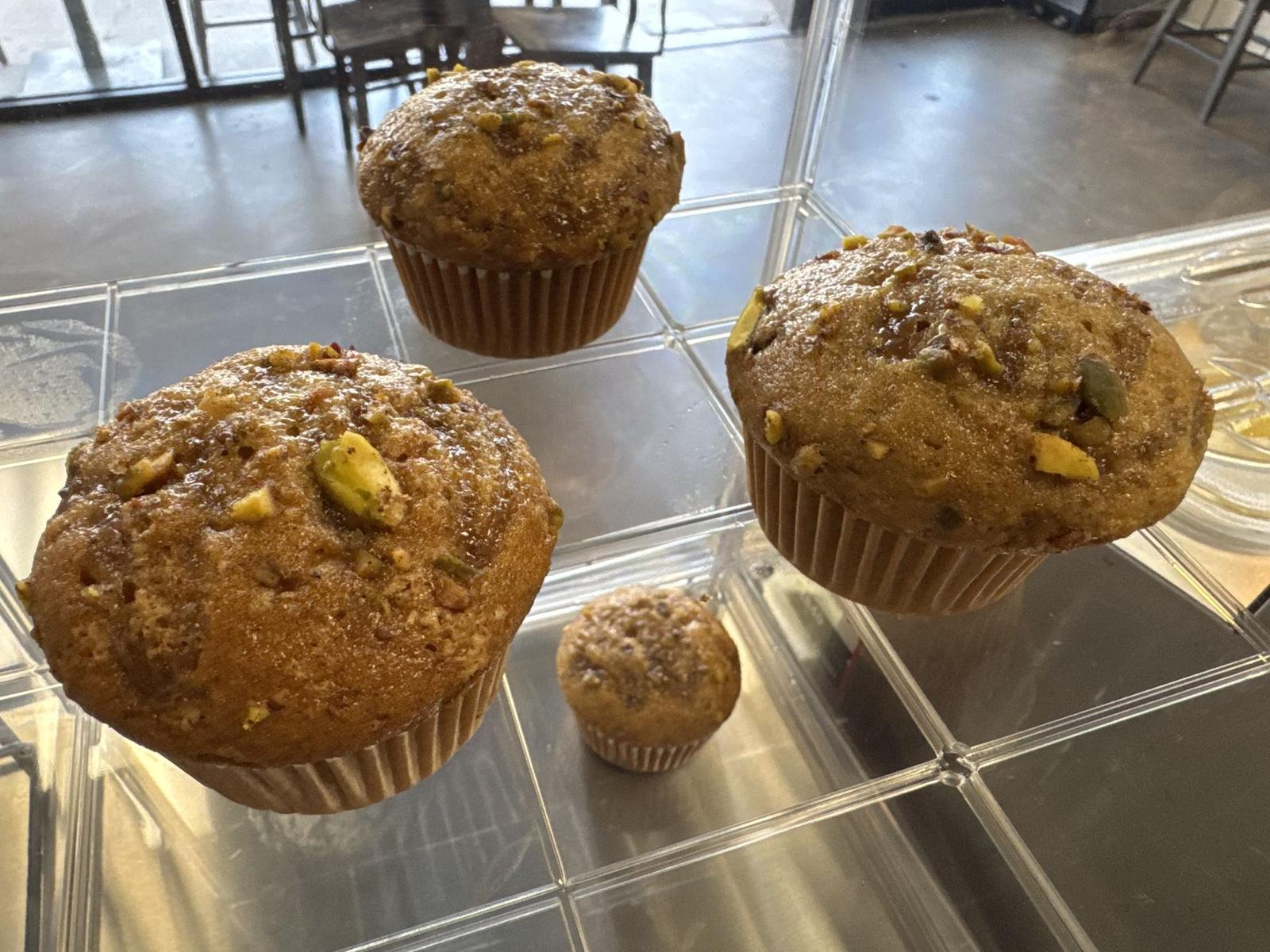 Pistachio crumble muffins topped with chopped pistachio and turbinado sugar